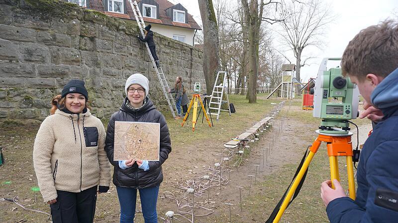 Jessica Weber und Jennifer Oleson (von links) und elf weitere Schüler des Gymnasiums Höchstadt vermessen einen Teil der Höchstadter Stadtmauer.   Hier stand einst der Zwickerturm.