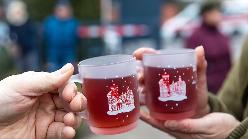 Menschen halten Tassen mit Glühwein Menschen halten Tassen mit Glühwein