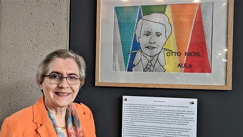 Margret Wolff aus M&uuml;nchen vor dem gestickten Portr&auml;t ihres Vaters und Schulgr&uuml;nders Otto Nickl in der jetzt nach ihm benannten Aula.