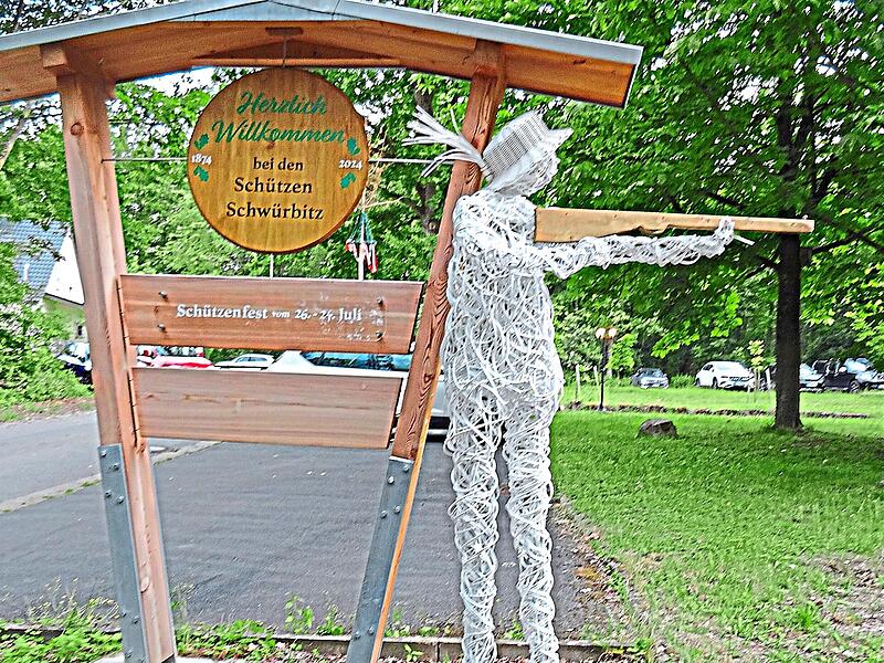 Begr&uuml;&szlig;ungsschild: Ganz in Wei&szlig; und mit einem geschnitzten Gewehr zeigt &bdquo;Werner&ldquo;, wo es zum Sch&uuml;tzenhaus und Festplatz geht.Stefan Motschenbacher