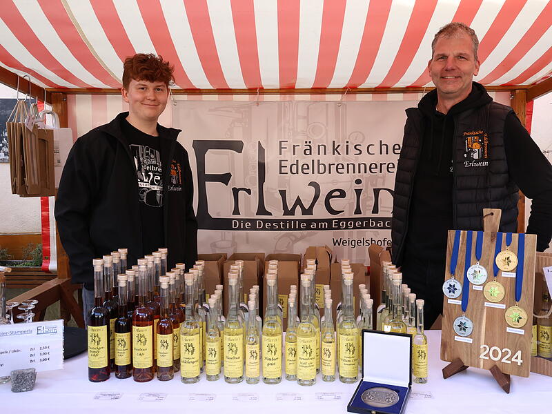 Matthias Erlwein und sein Sohn Jona stehen  am Stand mit ausgew&auml;hlten Brenn-Spezialit&auml;ten aus Weigelshofen.