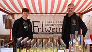 Matthias Erlwein und sein Sohn Jona stehen  am Stand mit ausgew&auml;hlten Brenn-Spezialit&auml;ten aus Weigelshofen.