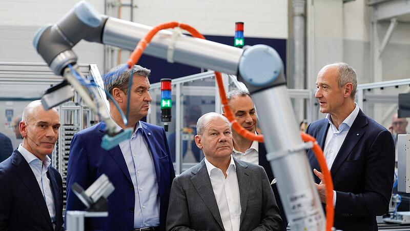 Konzernchef Roland Busch (r.) zeigt Kanzler Scholz und Ministerpr&auml;sident  S&ouml;der das Werk.