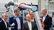 Konzernchef Roland Busch (r.) zeigt Kanzler Scholz und Ministerpräsident  Söder das Werk.