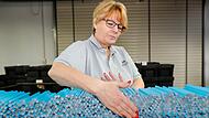 Trotz vollautomatischer Bleistiftstraße ist bei der Produktion von Holzstiften immer wieder Handarbeit gefragt. Liane Putala ordnet zwischen zwei maschinellen Stationen die Rohlinge auf eine Länge.
