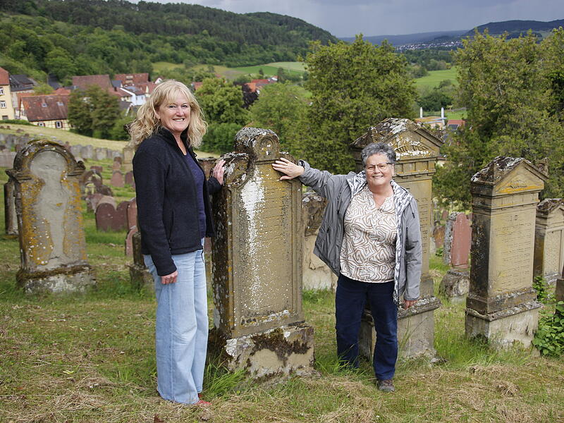 Kreisheimatpflegerin Cornelia Mence und Kulturleiterin Elli B&ouml;ck versuchen, einen der Grabsteine auf dem j&uuml;dischen Friedhof in Pfaffenhausen zu lesen.