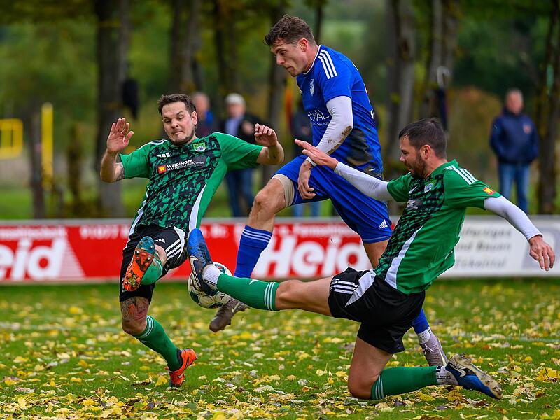 Reuths Spielertrainer Andre Jerundow veruscht sich aus der Neunkirchener Zange zu lösen.Forchheim & Fränkische Schweiz