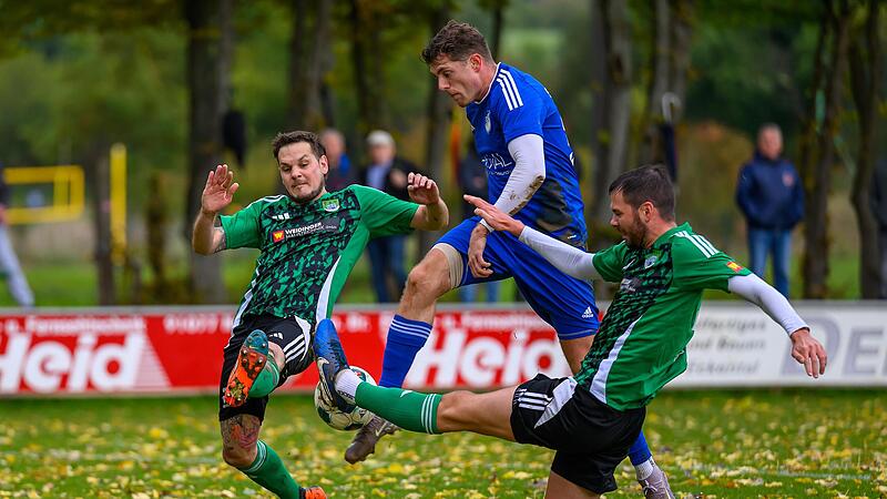 Reuths Spielertrainer Andre Jerundow veruscht sich aus der Neunkirchener Zange zu lösen.Forchheim & Fränkische Schweiz