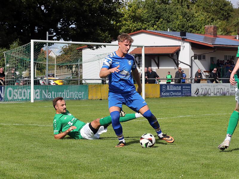 Der Hirschaider Torschütze Julian Hufnagel kann den Ball in Ruhe annehmern, da Michael Benoit vom SC Kemmern ausgerutscht ist.
