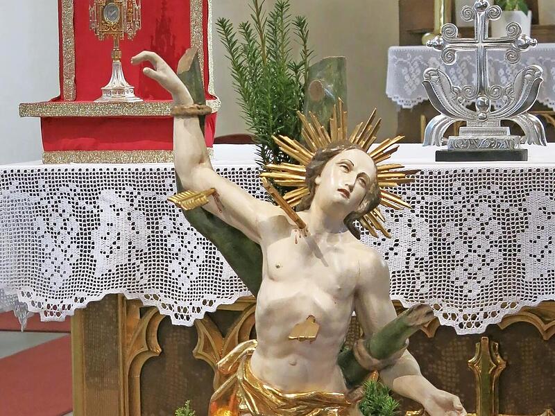 Die festlich geschm&uuml;ckte Statue des Heiligen Sebastian mit der Reliquienmonstranz (links) auf dem Volksaltar in der Pfarrkirche St. Thomas in Wallenfels.