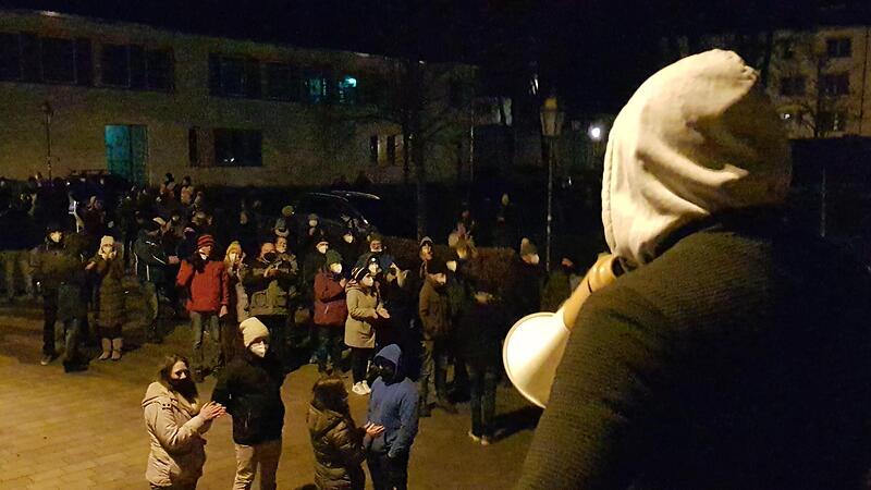 Kurz zuvor hat sich der junge Mann mit der Polizei geeinigt und &uuml;bernimmt den Posten des Versammlungsleiters. Zur Information der Anwesenden wendet er sich mit dem Megafon der Polizei an die Gruppe.