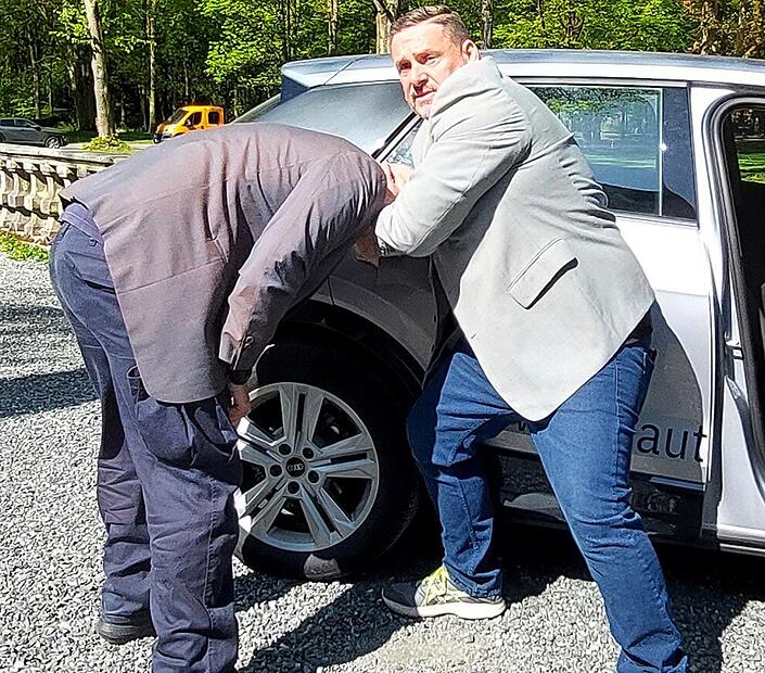 Stefan Schleicher (rechts) erkl&auml;rt, wie er sein Schutzperson in den Wagen "verfrachtet"