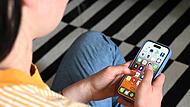 Eine Jugendliche sitzt auf dem Boden und nutzt ein Smartphone. Eine Jugendliche sitzt auf dem Boden und nutzt ein Smartphone.