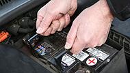 Mann wechselt eine Autobatterie