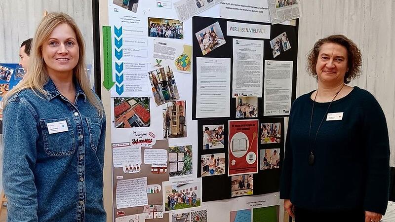 Eva Burkard (rechts) und Kerstin Pfost vor dem Info-Stand zu ausgew&auml;hlten Weltethos-Aktionen des LSH.