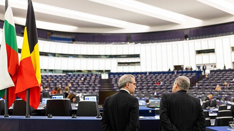 Zwei Saaldiener stehen im Plenarsaal im Geb&auml;ude des Europ&auml;ischen Parlaments.