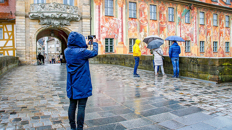 Sehensw&uuml;rdigkeit: Touristen betrachten das Alte Rathaus in Bamberg