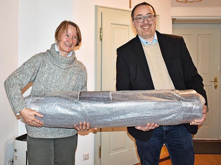 Beate Herbold vom Landesamt Bodendenkmal und Bürgermeister Martin Walz mit dem dick eingepackten „Baumstamm“, der historischen Holzwasserleitung.