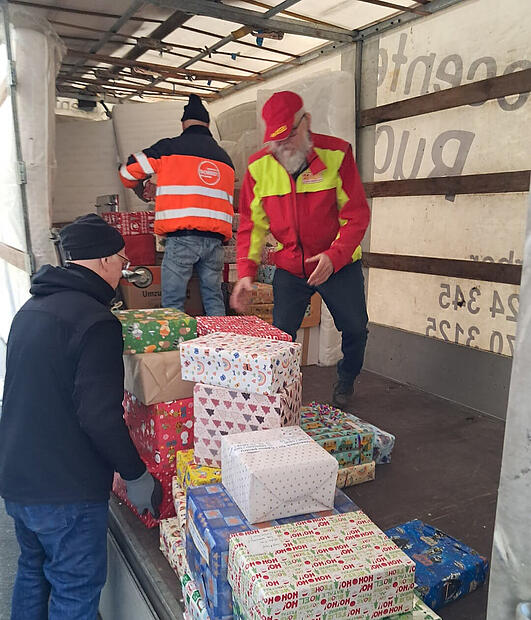 Helfer des ASB verladen Geschenkpakete in Hemhofen.