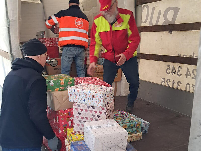 Helfer des ASB verladen Geschenkpakete in Hemhofen.