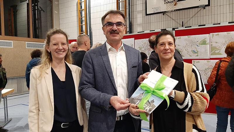 Christiane Wichmann und Leonie Kuhn (Architekturb&uuml;ro Perleth) &uuml;bergeben das 150-seitige Entwicklungskonzept an B&uuml;rgermeister Harald Hofmann.