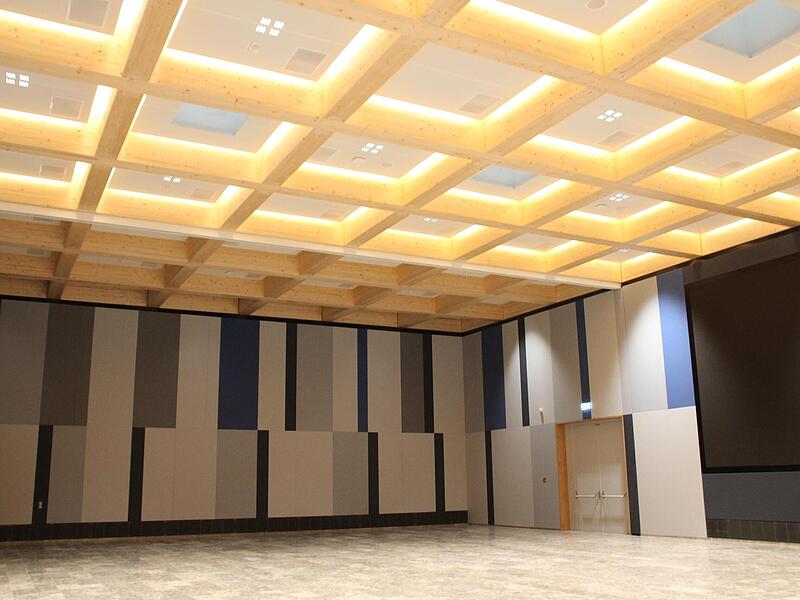 Die H&auml;user des Moduls 2 &ndash; das Bild zeigt die Konzerthalle der Empfangszentrale &ndash; sind zu gro&szlig;en Teilen aus Holz statt  nur aus Beton gebaut. Laut Siemens wurden dadurch beim Bau bis zu  80 Prozent CO2-Produktion vermieden.