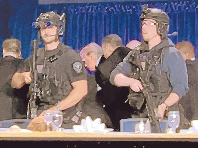 US-Geheimdienstmitarbeiter umringen US-Pr&auml;sidenten Donald Trump, Dritter von links, als er nach einer Schie&szlig;erei au&szlig;erhalb des Ballsaals von der B&uuml;hne gebracht wird.