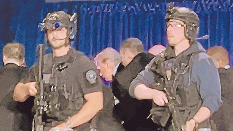 US-Geheimdienstmitarbeiter umringen US-Pr&auml;sidenten Donald Trump, Dritter von links, als er nach einer Schie&szlig;erei au&szlig;erhalb des Ballsaals von der B&uuml;hne gebracht wird.