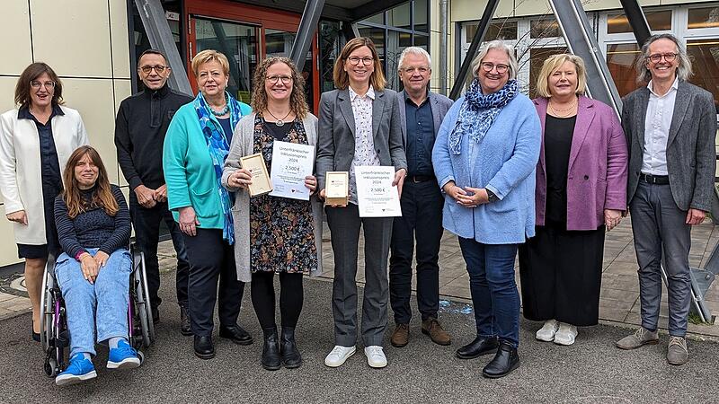 Das Foto zeigt (von links) Bezirksr&auml;tin Rosa Behon, Jurymitglied Sonja Scheuplein in Begleitung von Roland Hascher, die Behindertenbeauftragte des Bezirks Gerlinde Martin, die Initiatorinnen des Projekts Shelly Preu und Anja Bank, Jurymitglied Thomas Hetterich, Kitzingens B&uuml;rgermeisterin Astrid Glos, die Leiterin der Grundschule Kitzingen Siedlung Heike Schneller-Schneider und den Leiter der St. Martin-Schule Cornelius Breyer.