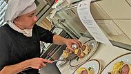 Ben Rummel, Koch-Azubi im Restaurant Braunsmühle in Bischofsheim, beim Anrichten seines Hauptgerichts