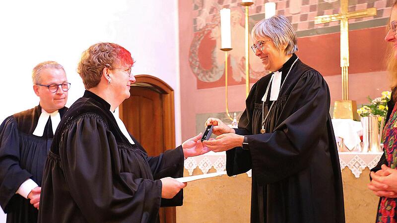 Die Bayreuther Regionalbisch&ouml;fin Dorothea Greiner &uuml;berreicht Raphaela Holzinger (links) das Ordinationskreuz und die Ordinationsurkunde.