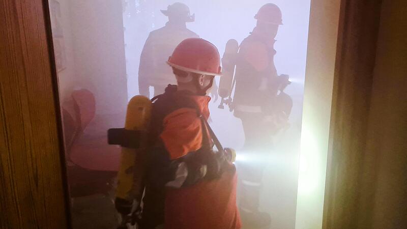 Junge Feuerwehrleute dringen bei der Übung in das künstlich verrauchte Schulhaus ein, um Personen zu retten.Forchheim & Fränkische Schweiz