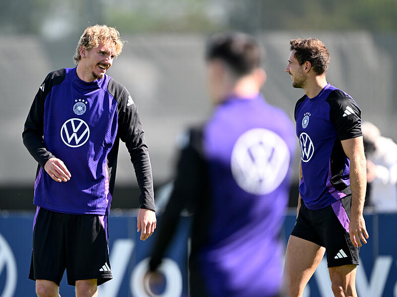 Nick Woltemade (links) im Austausch mit Leon Goretzka während des DFB-Trainings in Herzogenaurach.