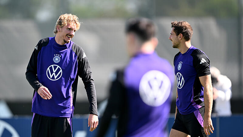Nick Woltemade (links) im Austausch mit Leon Goretzka w&auml;hrend des DFB-Trainings in Herzogenaurach.