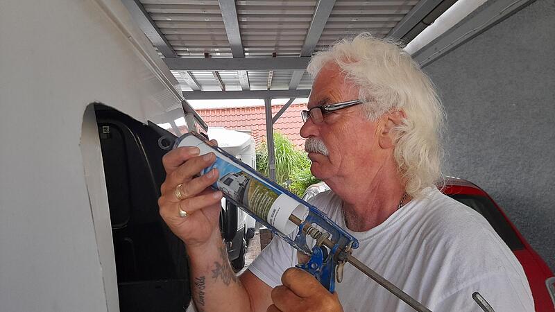 Mit einer Spezialmasse dichtet Harry Gnech das neue Fenster im Ford Transit Mattes ab.