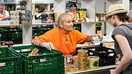 Alltag bei der Kitzinger Tafel: Eine ehrenamtliche Mitarbeiterin gibt einer Kundin Lebensmittel aus. Alltag bei der Kitzinger Tafel: Eine ehrenamtliche Mitarbeiterin gibt einer Kundin Lebensmittel aus. 