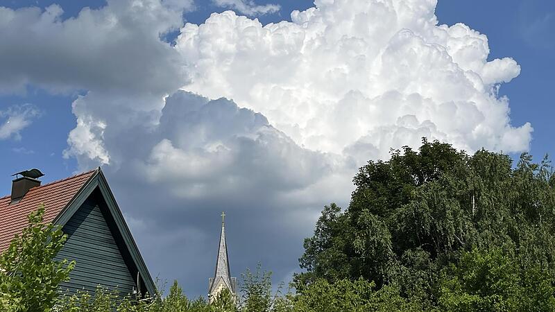 Gewitterträchtige Haufenwolken in dampfig-warmer Luft sind über der Kirchturmspitze der Stadtkirche von Ebermannstadt zu sehen. Dieser Wolken-Mix ist für den Juni typisch.Forchheim & Fränkische Schweiz