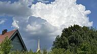 Gewitterträchtige Haufenwolken in dampfig-warmer Luft sind über der Kirchturmspitze der Stadtkirche von Ebermannstadt zu sehen. Dieser Wolken-Mix ist für den Juni typisch.Forchheim & Fränkische Schweiz