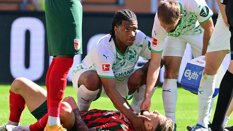 So hatte sich Niklas Dorsch (am Boden) das Saisonende nicht vorgestellt. Gegen F&uuml;rth brach sich der Altenkunstader das Schl&uuml;sselbein. Die F&uuml;rther Jessic Ngankam (li.) und Simon Asta &uuml;bernehmen die Erstversorgung.