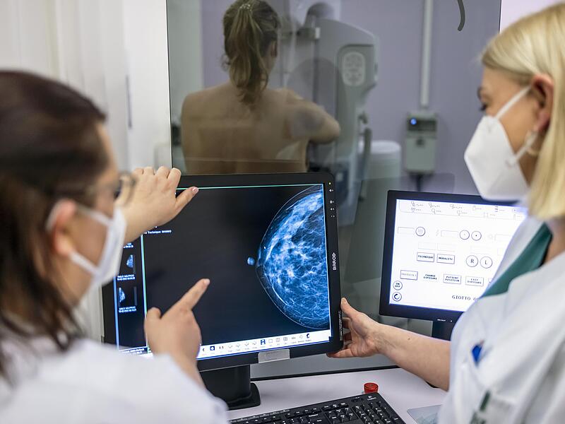 Medizinisches Personal untersucht mit einer Mammografie die Brust einer Frau auf Brustkrebs.