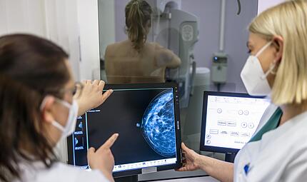 Medizinisches Personal untersucht mit einer Mammografie die Brust einer Frau auf Brustkrebs.