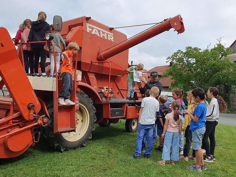 Tim Scheppe erkl&auml;rt den Kindern, was ein M&auml;hdrescher alles kann.