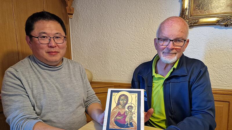 Diakon Kim Sell und Heribert Vogler (Vertreter des Arbeitskreises Maria Ehrenberg) präsentieren die Ikone des Maria Ehrenbergs, die in diesem Jahr den Zelebranten als Gastgeschenk mitgegeben wird.