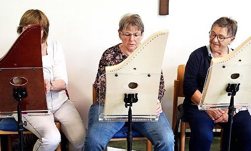 Auf dem Foto von links: Saiten-Klang-Spielerin Edeltraud Milner. Ursula Ziegler aus dem Diebacher Team versucht sich unter Anleitung an der Veeh Harfe. Und neben ihr Saiten-Klang-Spielerin Monika Hofmann.