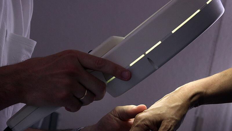 Ein Hautarzt untersucht eine Patientin bei der Hautkrebs-Vorsorge