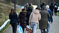 Geflüchtete nach ihrer Registrierung auf dem Weg in eine Unterkunft