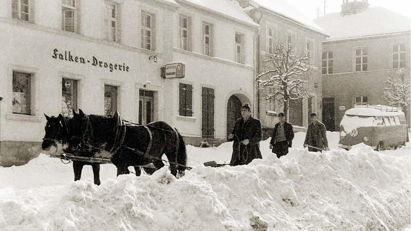 Winterimpression 1956: Mit einem Haflinger-Gespann wird die die Marktstra&szlig;e von meterhohem Schnee ger&auml;umt.