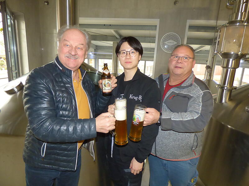 Conny Krug (r.) und sein Braumeister Kurt K&auml;sperlein sto&szlig;en mit ihrem japanischem Praktikanten Kentaro Shinada mit dessen Lieblingsbier &bdquo;Ur-Stoff&ldquo; an.