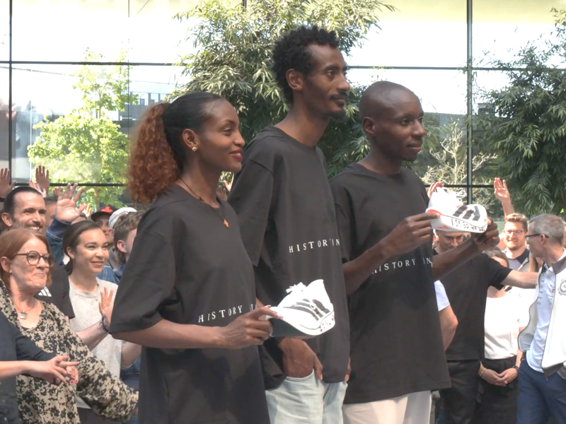 Tigist Assefa (v.l.), Yomif Kejelcha und Sabastian Sawe lassen sich in Herzogenaurach von Hunderten Mitarbeitern des Sportartikelherstellers feiern.