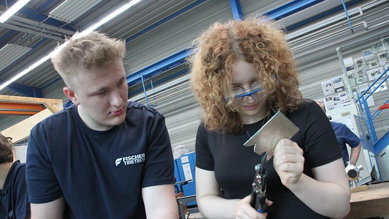 Unter Anleitung von Lehrling Jan Pfeil von Fischer Tire Tech lernt Realschülerin Victoria Krappmann wie man mit einer Handblechschere arbeitet.